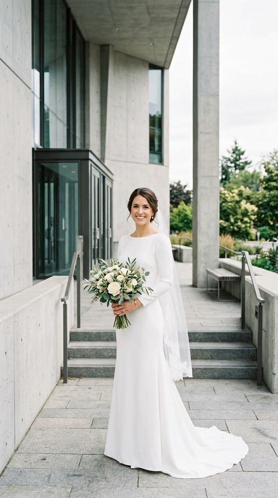A bride in a white matte crepe wedding dress with clean lines outside a modern courthouse